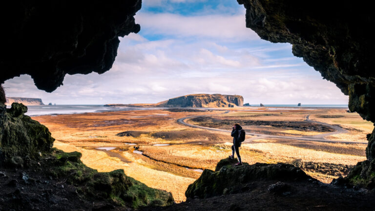 Mujer al borde de una cueva contemplando un paisaje costero abierto al amanecer, símbolo de una nueva etapa vital. Foto: Giuseppe Milo, CC BY 3.0 (Wikimedia Commons)